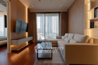 Modern living room with large windows and city view, featuring a sleek TV setup and cozy seating area.