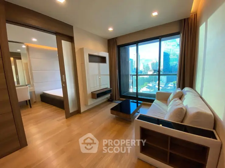 Modern living room with city view, featuring sleek furniture and large windows for natural light.