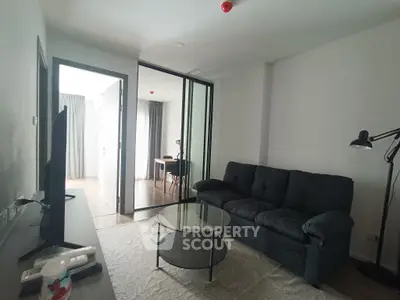 Modern living room with glass partition, cozy sofa, and stylish decor