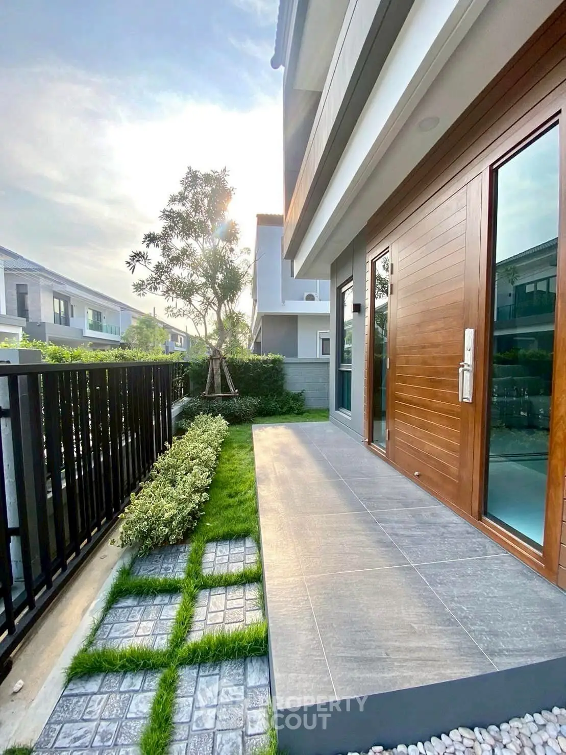 Modern townhouse with elegant wooden door and landscaped garden