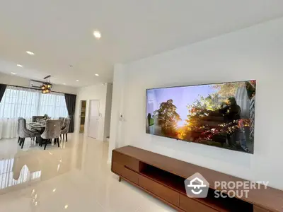 Spacious modern living room with elegant dining area and large wall-mounted TV