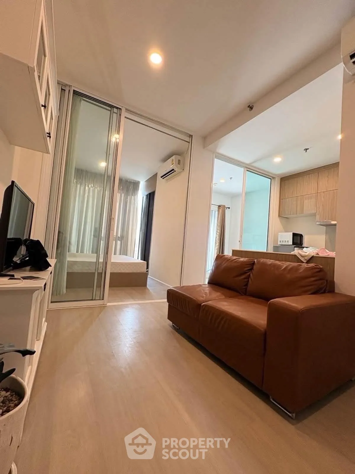 Modern apartment interior with cozy living room and open kitchen layout, featuring stylish furniture and natural light.
