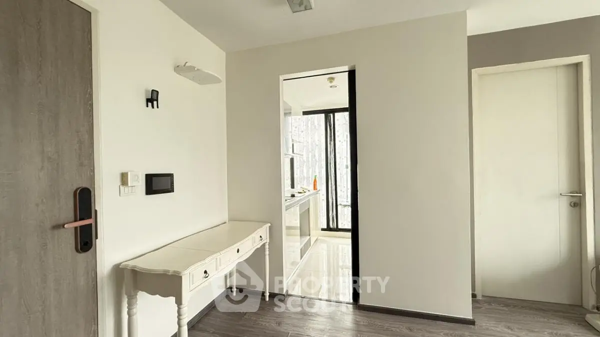 Modern apartment hallway with elegant console table and view into bright kitchen