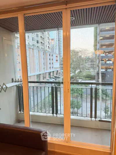 Modern apartment balcony with sliding glass doors and urban view