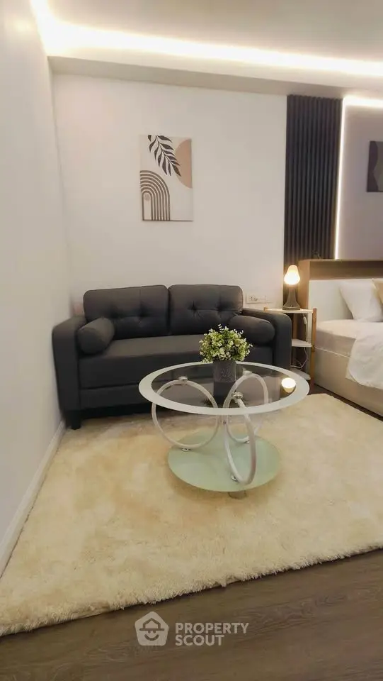 Modern living room with stylish sofa and glass coffee table on plush rug
