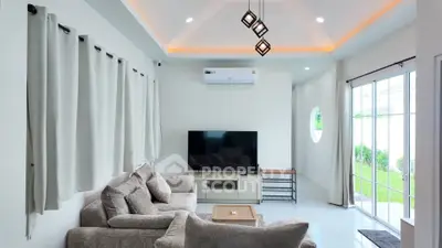 Modern living room with cozy sofa, large TV, and stylish lighting