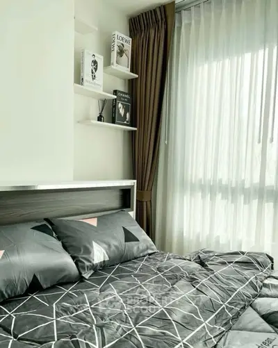 Modern bedroom with stylish bedding and natural light from large window