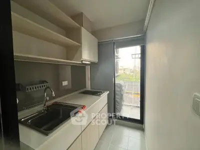 Modern compact kitchen with sleek cabinetry and balcony access