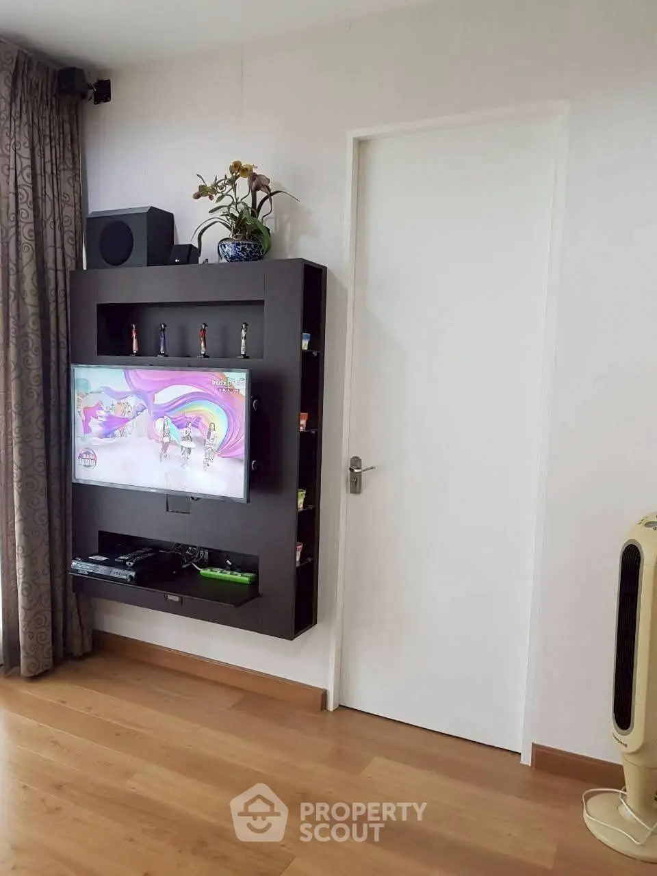 Modern living room with wall-mounted TV and sleek wooden flooring