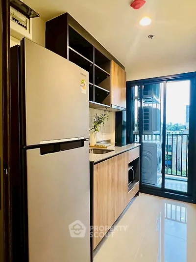 Modern kitchen with sleek appliances and balcony view in urban apartment