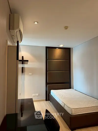 Modern bedroom with sleek design, featuring a comfortable bed, air conditioning, and stylish furniture.