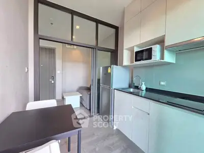 Modern kitchen with sleek cabinetry and dining area in a stylish apartment
