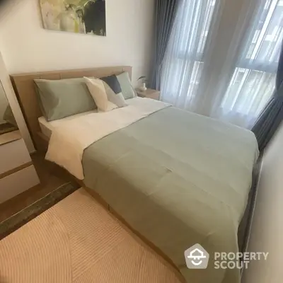 Cozy bedroom with modern decor and natural light from large windows.