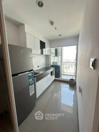 Modern kitchen with sleek appliances and balcony view in urban apartment