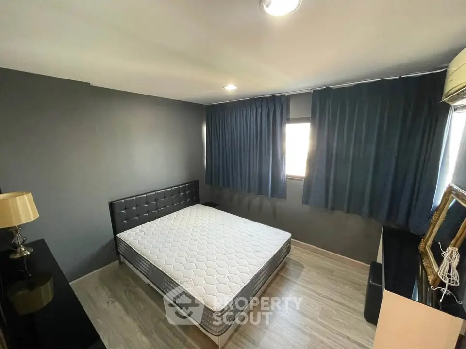 Modern bedroom with stylish decor and natural light, featuring a comfortable bed and sleek furnishings.