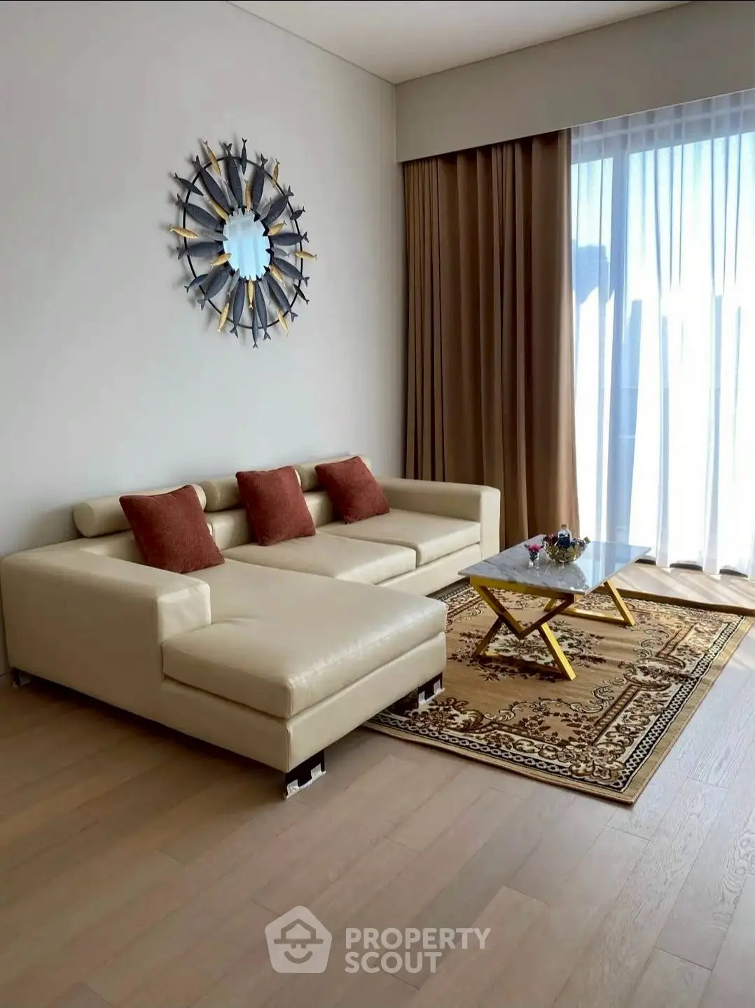 Elegant living room with modern beige sofa, stylish decor, and large window for natural light.