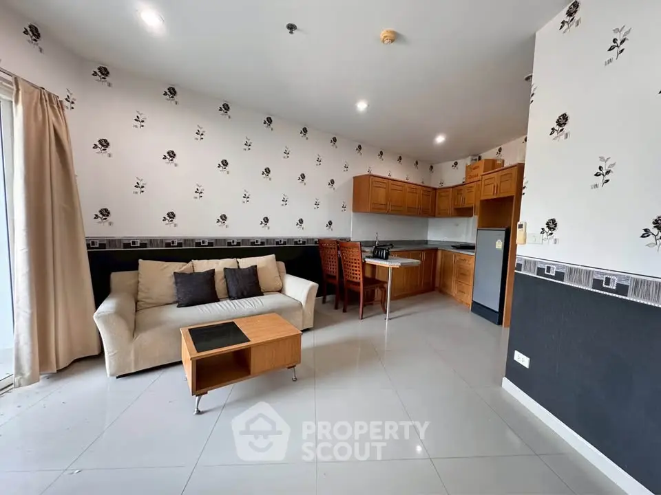Spacious living room with modern kitchen in open layout, featuring elegant decor and ample natural light.