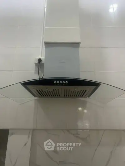 Modern kitchen with sleek range hood and tiled backsplash