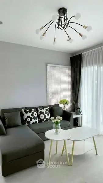 Modern living room with stylish chandelier and cozy sectional sofa