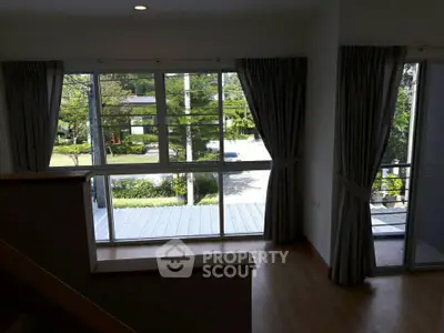 Spacious room with large windows offering a serene garden view, perfect for natural light lovers.