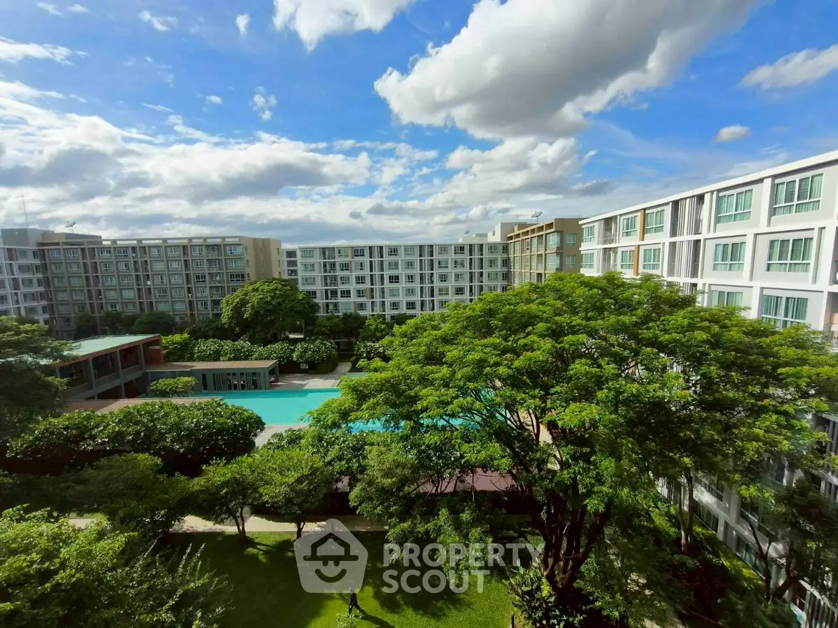 Stunning view of modern apartment complex with lush greenery and inviting pool area.