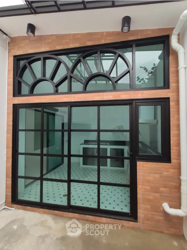 Modern exterior with large windows and brick facade, showcasing stylish architectural design.