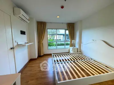 Spacious bedroom with large window and wooden floor, ready for customization.