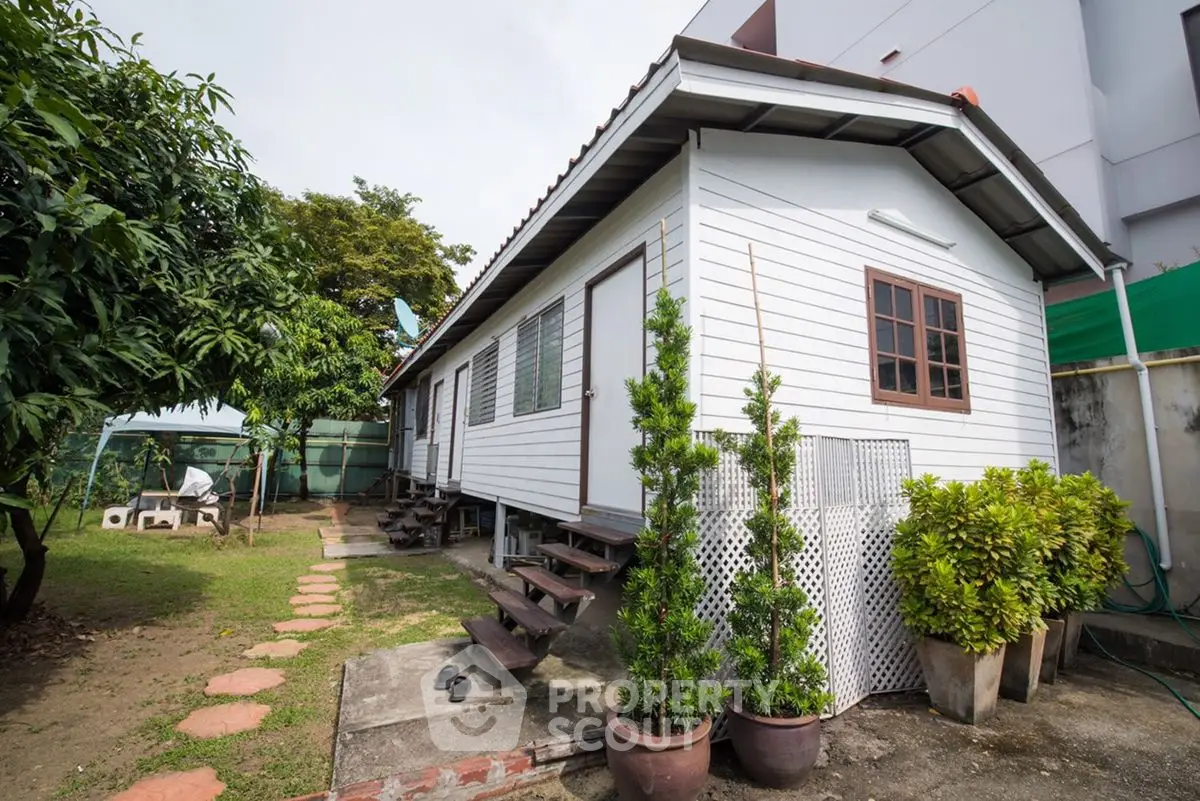 Charming white wooden house with lush garden and stepping stone path
