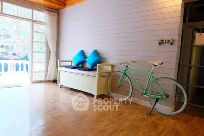 Charming interior with wooden floors, cozy seating, and a vintage bicycle, perfect for modern living.