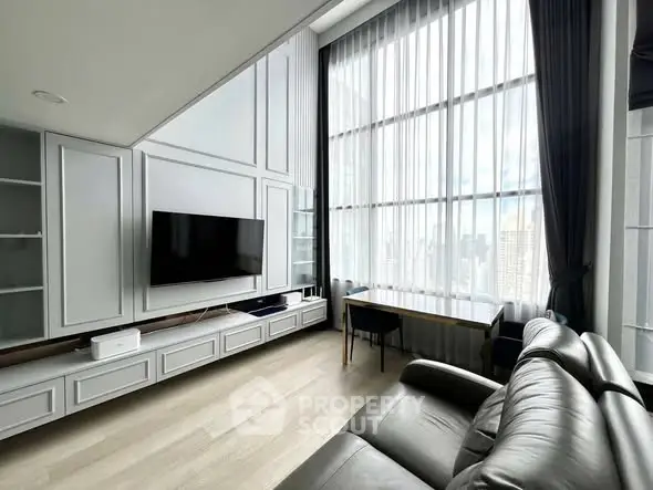 Spacious modern living room with high ceilings and large windows offering city views.