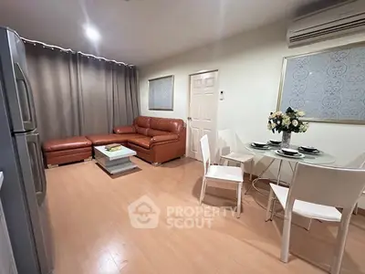 Modern living room with leather sofa and dining area in open layout apartment.