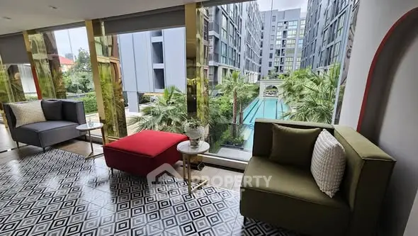 Luxurious modern living room with pool view in upscale apartment complex.