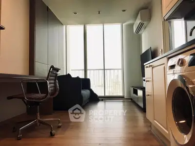 Modern studio apartment with sleek furniture and large windows offering natural light.