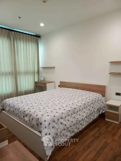 Cozy bedroom with modern wooden furniture and natural light through large window.