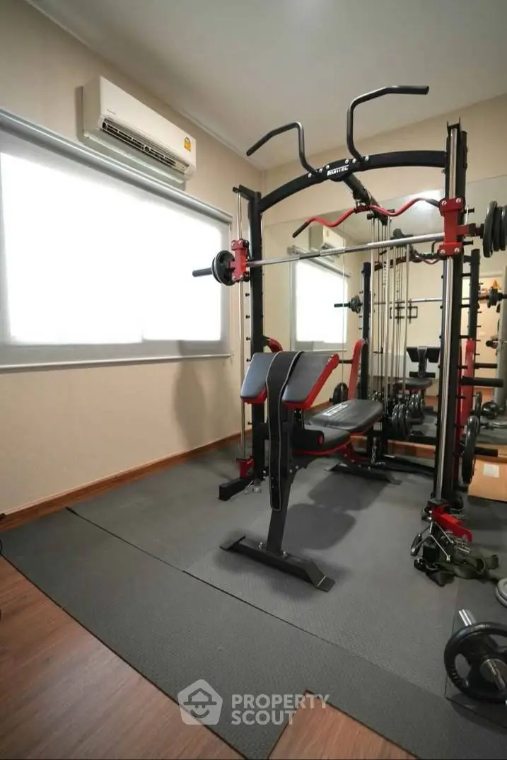 Modern home gym with state-of-the-art equipment and wooden flooring, perfect for fitness enthusiasts.