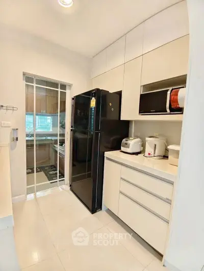 Modern kitchen with sleek appliances and ample storage in a stylish apartment.