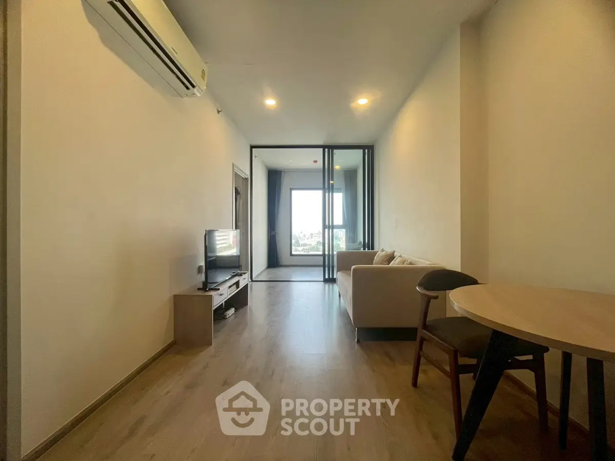 Modern living room with sleek design and city view, featuring a cozy sofa and stylish furniture.