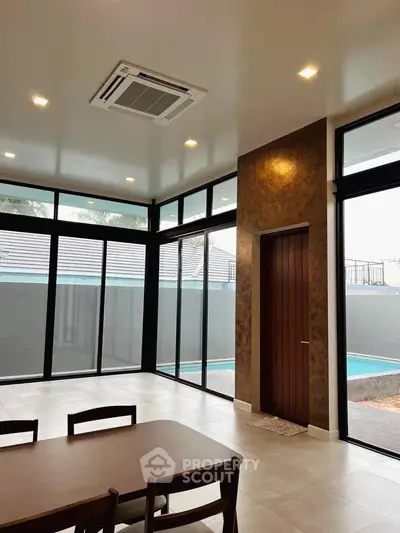 Spacious modern living room with large windows and pool view