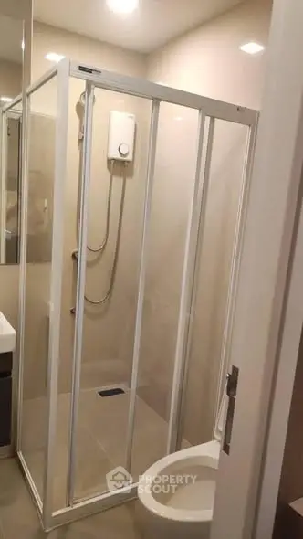 Modern bathroom with glass shower enclosure and sleek fixtures.