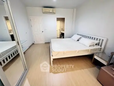 Spacious bedroom with modern design and mirrored wardrobe in a cozy apartment.