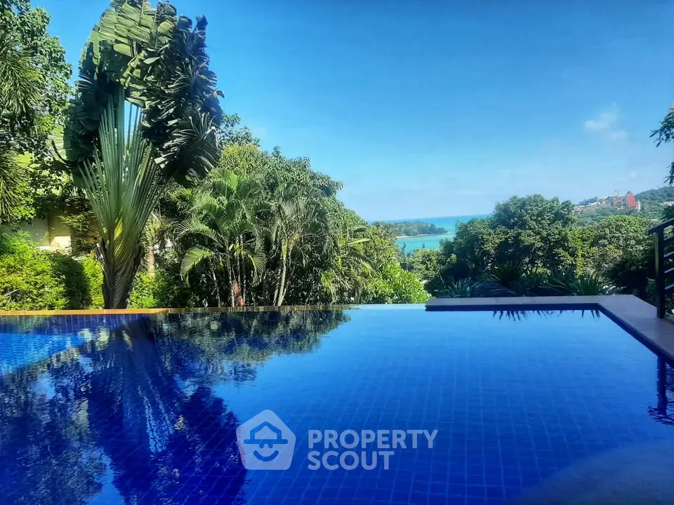 Stunning infinity pool with lush greenery and ocean view, perfect for luxury living.