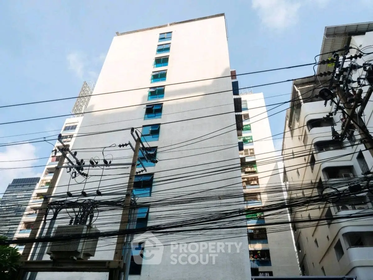 High-rise residential building with blue windows and urban surroundings.