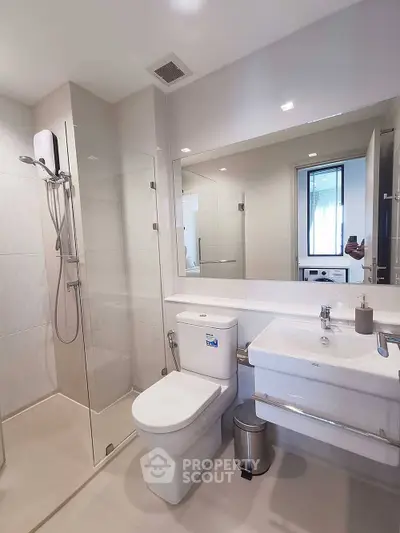 Modern bathroom with glass shower and sleek fixtures in a contemporary home.