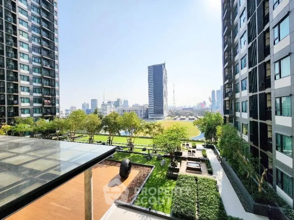 Stunning cityscape view from modern apartment balcony with lush garden and skyline backdrop.