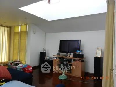 Spacious living room with skylight and modern entertainment setup