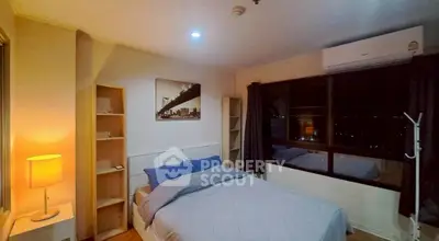 Cozy bedroom with modern decor and large window offering city views.