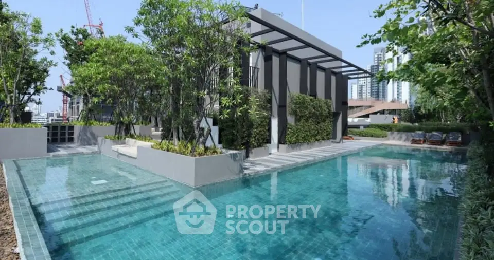 Luxurious modern pool area with lush greenery and cityscape views, perfect for relaxation and leisure.