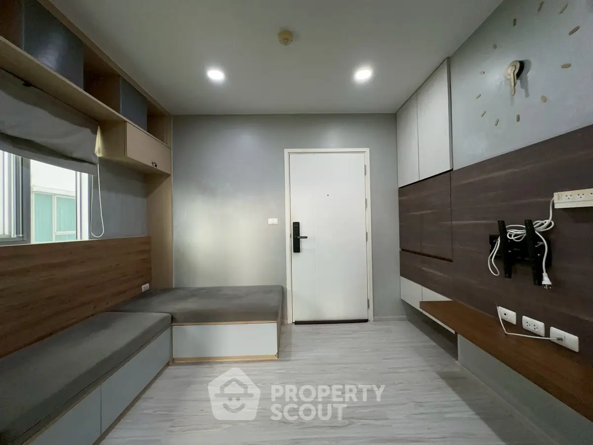 Modern minimalist living room with built-in storage and sleek design.