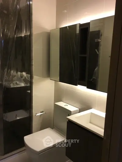 Modern bathroom with sleek fixtures and illuminated mirror