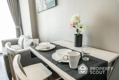 Modern dining area with elegant table setting and cozy seating in a stylish apartment.